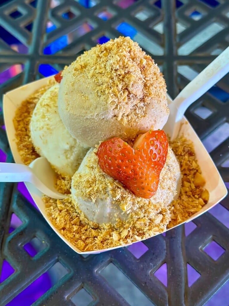 MOSA! three scoops of ice cream topped with peanuts and fresh strawberries.