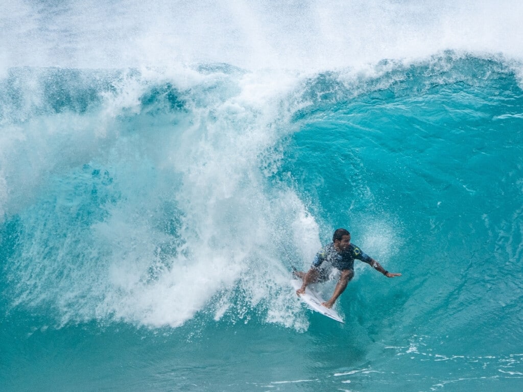 Pro surfer riding a wave at the Vans Triple Crown of Surfing on Oahu’s North Shore.