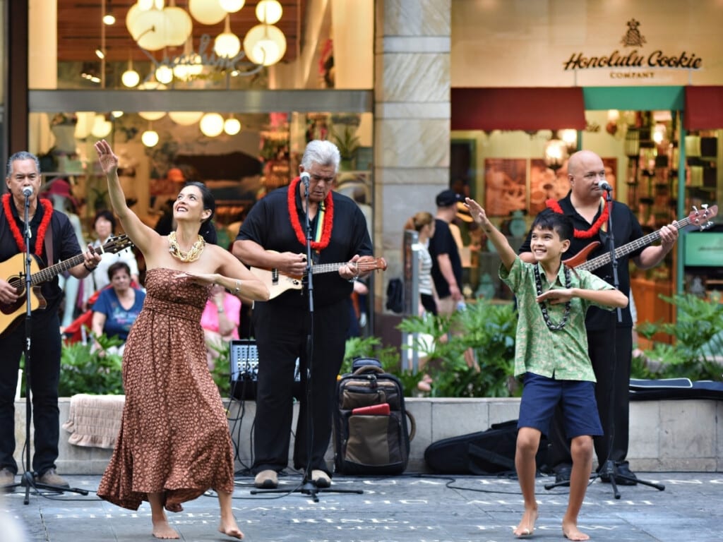 Kū Haʻaheo hula performance with band at Waikiki Beach Walk.