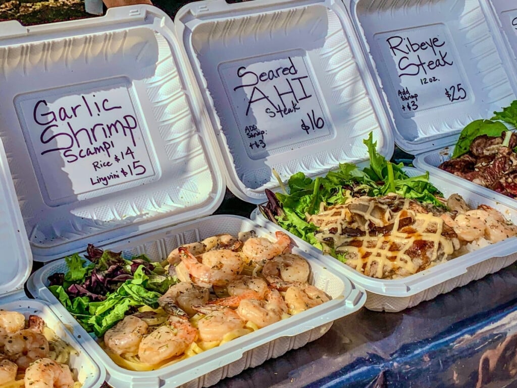 Hawaiian plate lunch on display including garlic shrimp scampi linguini and seared ahi steak at salad at KCC Farmers Markets.
