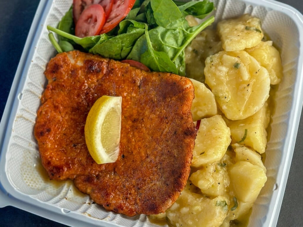 Take away plate of fresh jagerschnitzel with creamy potatos and salad from Aloha German Bakery at Kaka’ako Farmers Market in Honolulu.