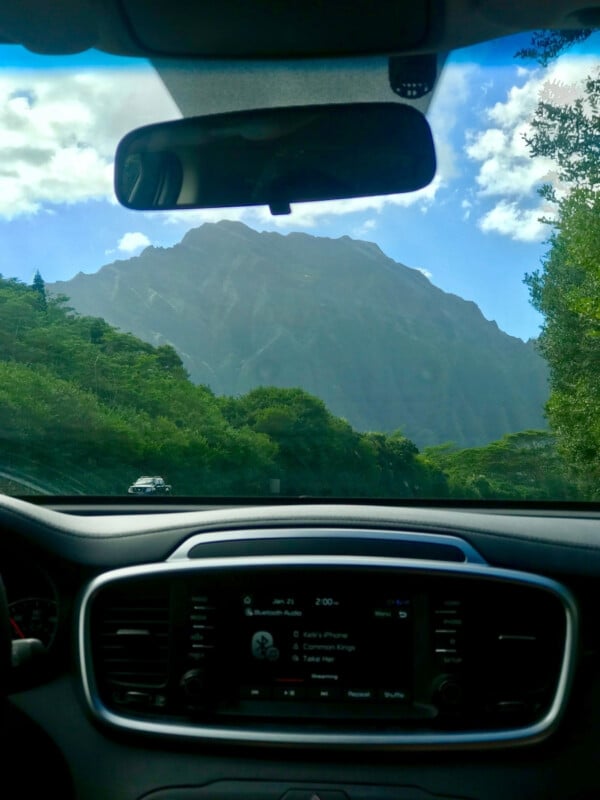 Looking out of the car front windshield at Oʻahu's lush mountains.