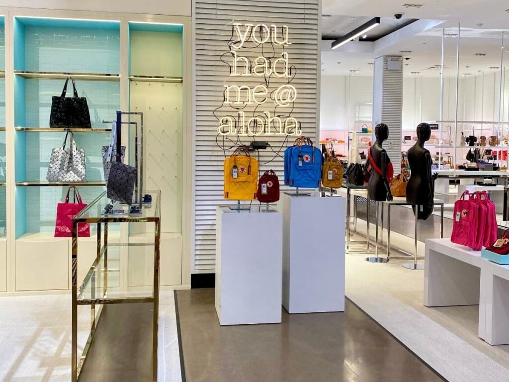 Colorful display of bags inside Bloomingdales at Ala Moana Center with neon sign that says "you had me @ aloha"