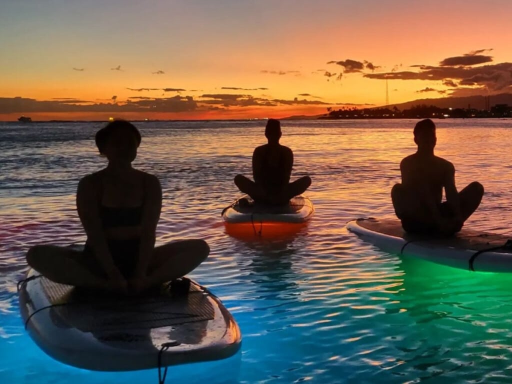 Night Stand Up Paddleboard Yoga with Yoga Floats at Ala Moana Beach Park.
