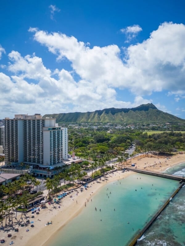 The Twin Fin Hotel building on Kalākaua Avenue in Wakīkī with Diamond Head in the background.