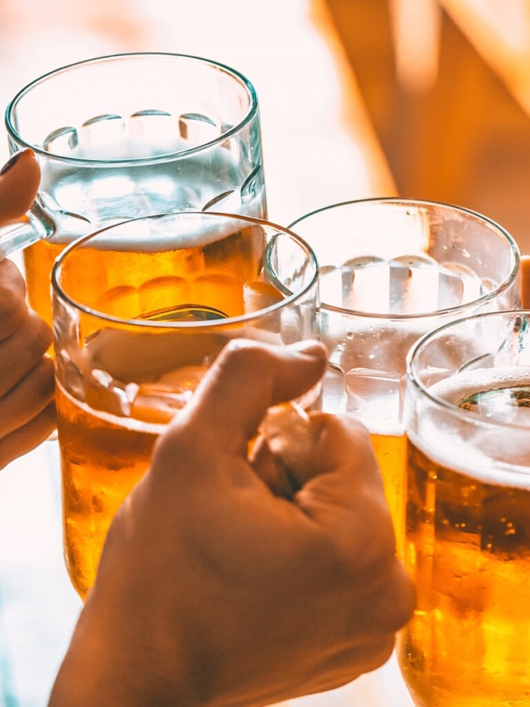 Friends toasting with glasses of light beer.