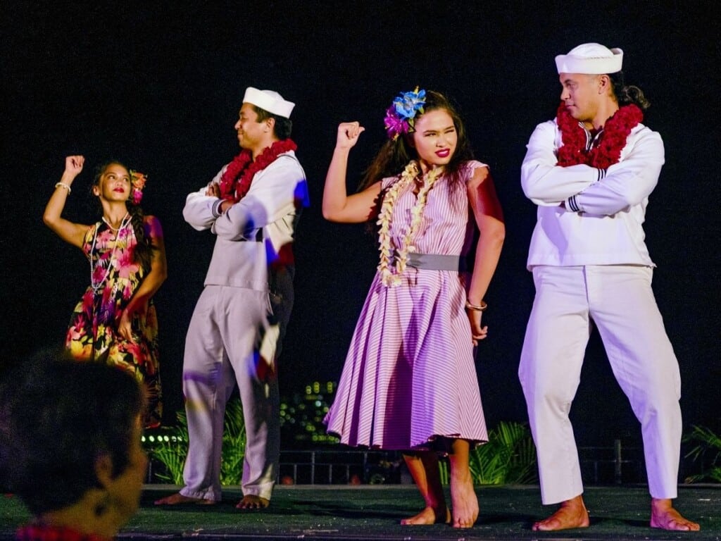 Dancers wearing sailor outfits and 1940s-style dresses perform during the Ahaʻaina Luau at the Royal Hawaiian.