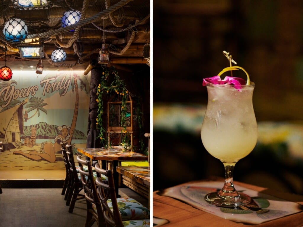 Left: The bar area of Yours Truly, a Honolulu speakeasy bar decorated with wooden furniture colorful lanterns. There is a vintage illustration that covers the back wall which shows a hula girl relaxing in the sand with Diamond Head in the background. Right: craft cocktail garnished with a pink orchid on a wooden table.