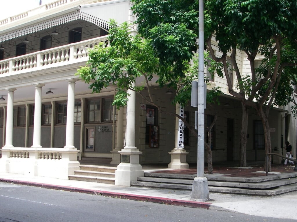 White exterior building of of Kumu Kahua Theatre with pillars and entrance. 