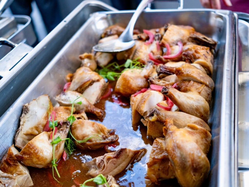Bain-marie filled with Huli Huli Chicken, Pickled Red Onion, Smoked Jus Pāʻina Waikīkī Luau.