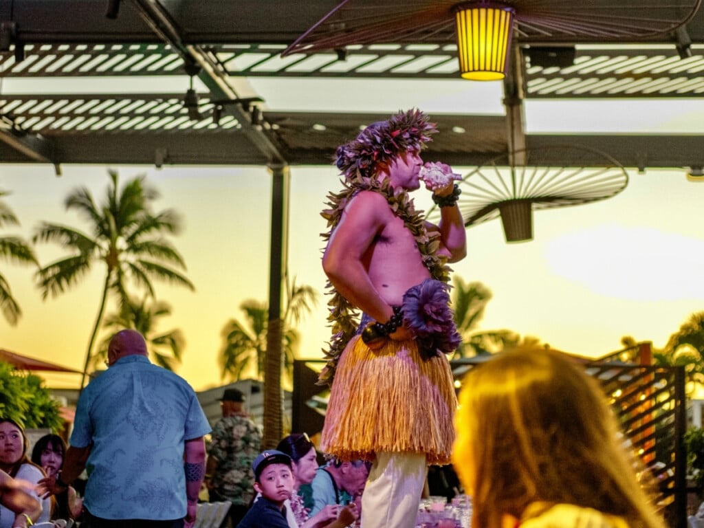 A performer blows a conch shell (pū) to kick off the show at Pāʻina Waikīkī Luau.
