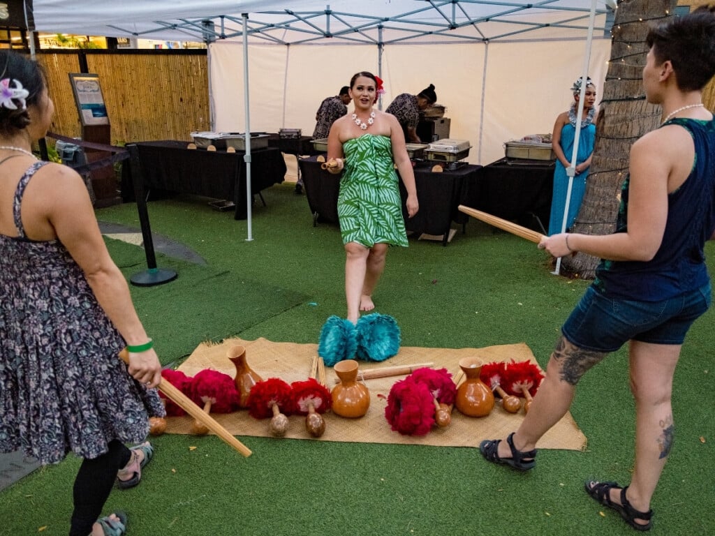 Guests engage in interactive cultural activities and learn how to use authentic Hawaiian dance and music instruments at the Queens Waikiki Luau.