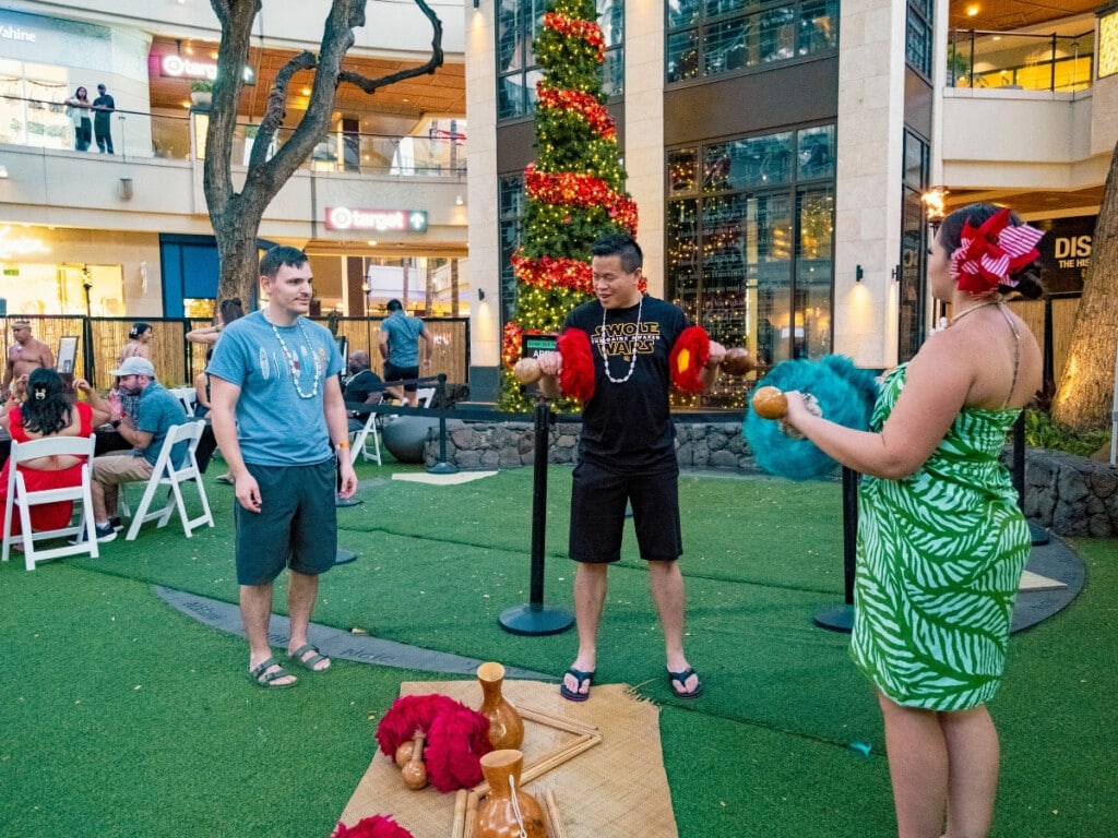 Guests engage in interactive cultural activities and learn how to use authentic Hawaiian dance and music instruments at the Queens Waikiki Luau.