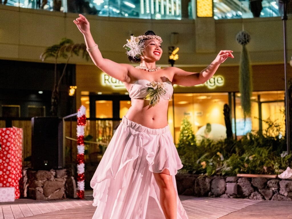 Tahitian dancer performing at Queens Waikiki Luau adorned in traditional attire.