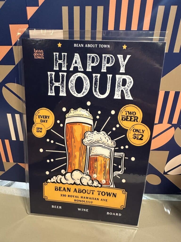 The Happy Hour sign from Bean About Town in Waikīkī featuring $12 for two beers.
