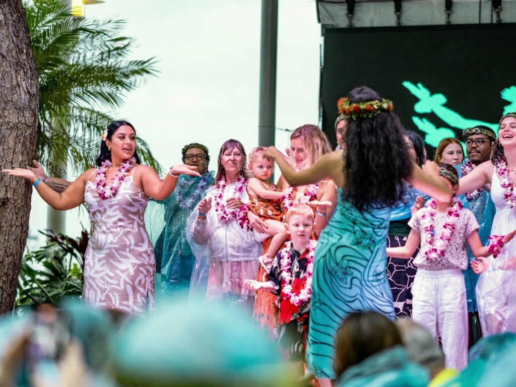 Guests participate it a group hula lesson on the stage at Ka Moana Luau.
