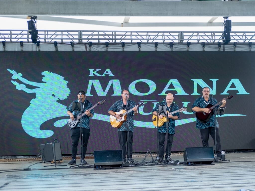 The band at Ka Moana Lūʻau, backed with a digital screen.