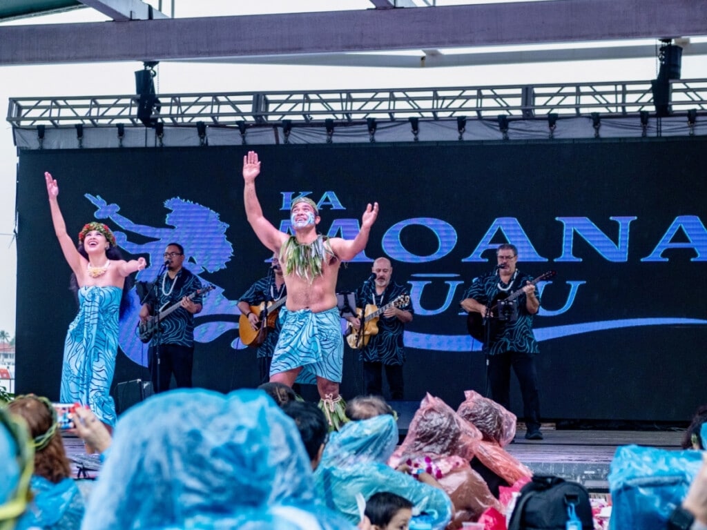 A lively band plays music while two hula dancers perform at the Ka Moana Luau.
