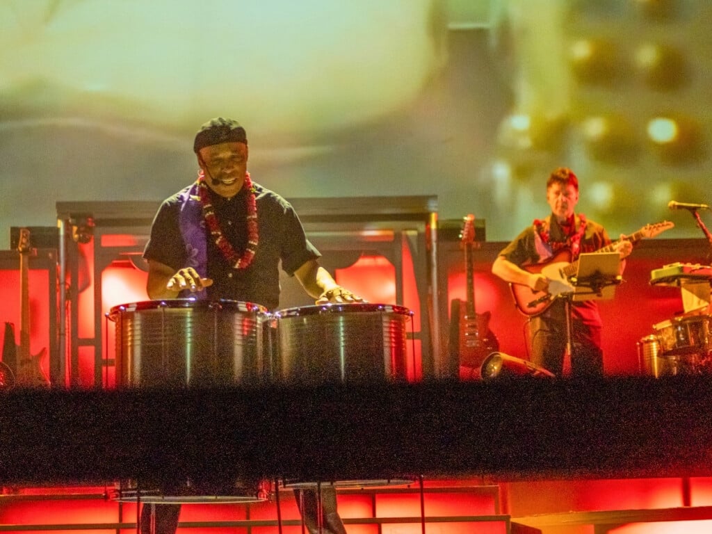 Band performs live at the Rock-A-Hula Show with close up of drummer and guitarist.