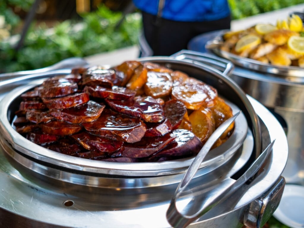 A plate of Passion Fruit Roasted Uala Sweet Potatoes on the Waikiki Luau Buffet & Rock-A-Hula Show buffet line.