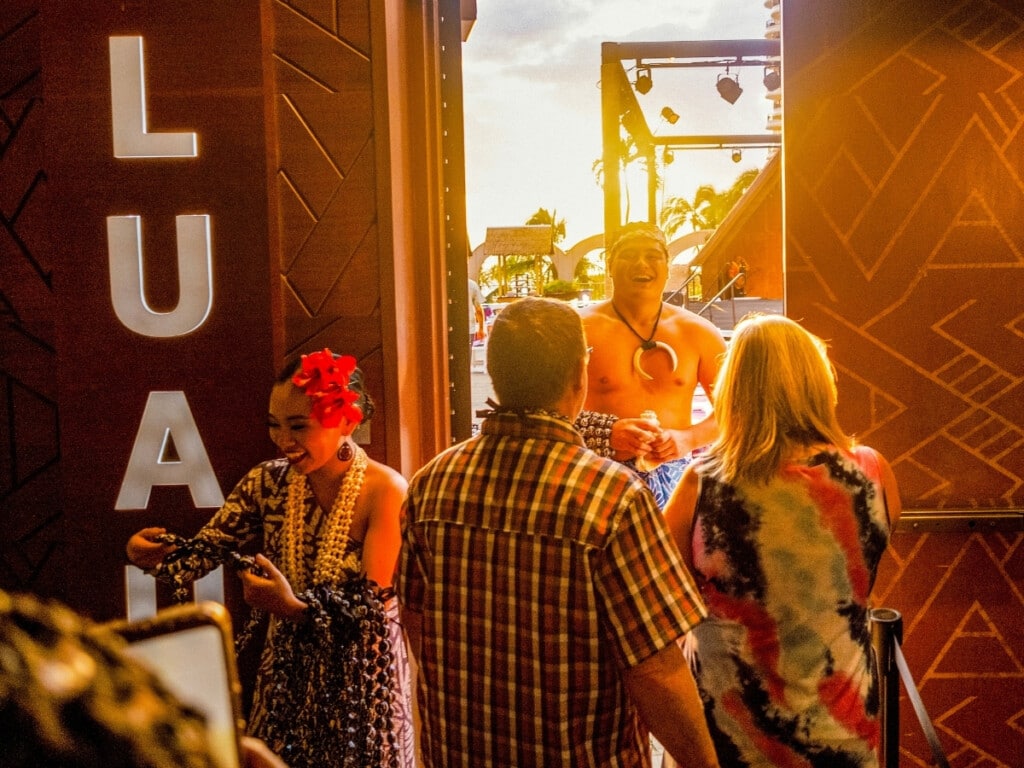 Guests being welcomed with a Kukui nut lei greeting at the entrance of the Waikiki Starlight Luau: Rooftop.
