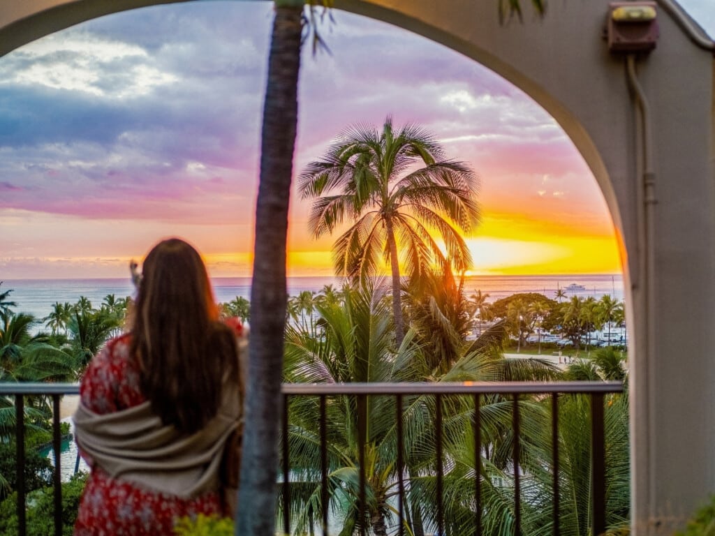 Lady watches the sunset over Duke Kahanamoku Lagoon and the marina from Waikiki Starlight Luau: Rooftop.