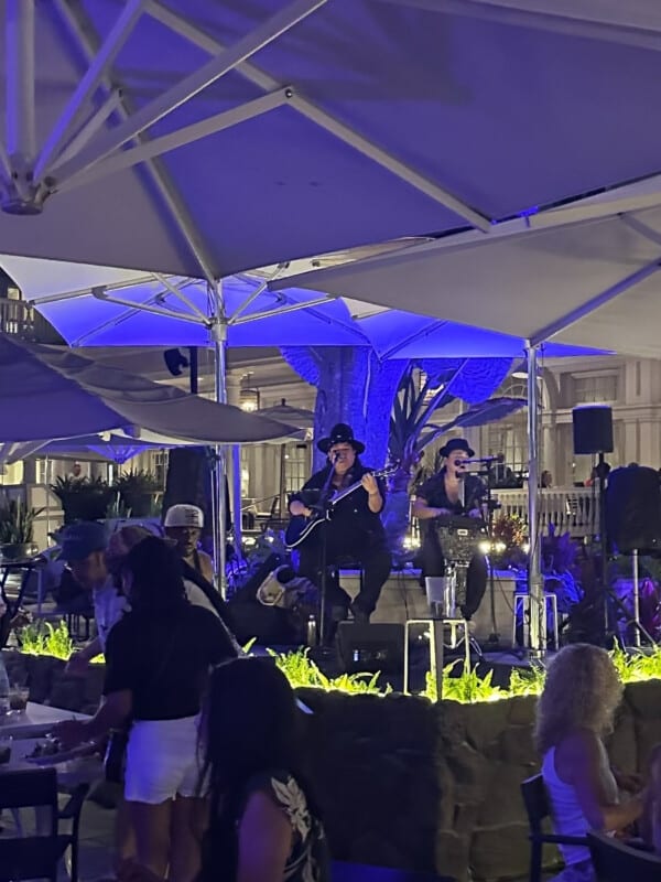 Live music being performed at The Beach Bar under the banyan tree in purple lighting at Moana Surfrider, A Westin Resort in Waikīkī.