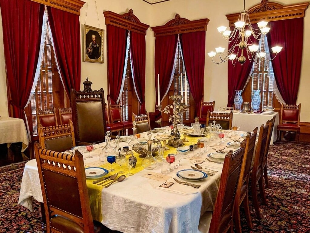 The State Dining Room at ʻIolani Palace. The dining table is set with fine china and crystal.